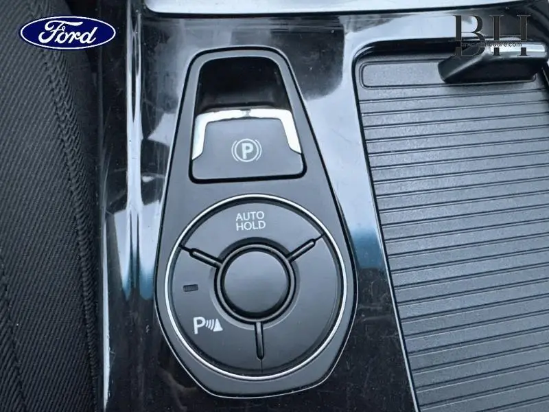 Gros plan sur la console centrale noire brillante d'une Hyundai i40 SW Sleek Silver avec commandes Auto Hold et frein à main électronique.