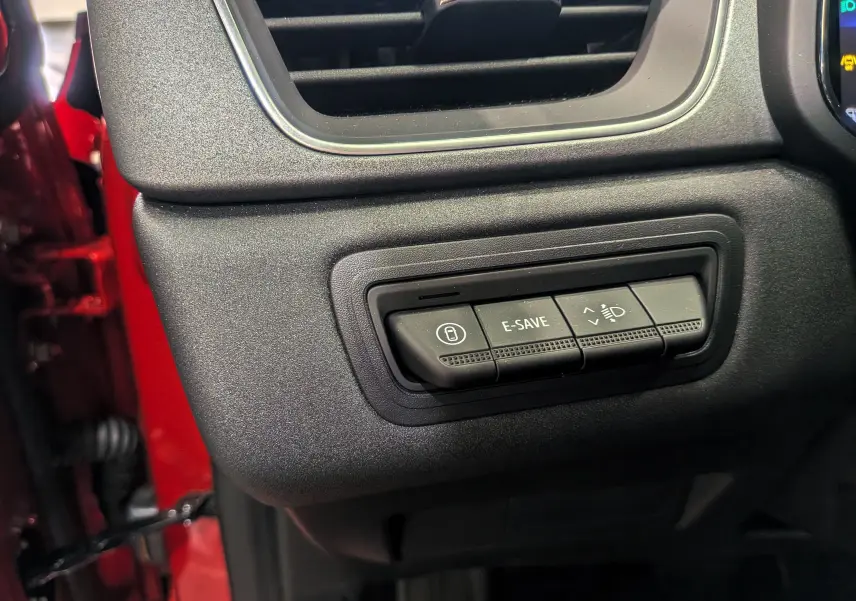 Boutons de commande E-SAVE et réglage des phares sur le tableau de bord du Renault Captur rouge Flamme 2025.
