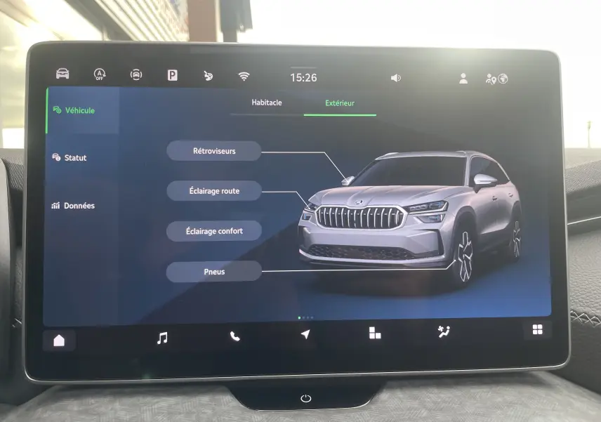 Écran tactile affichant une vue 3/4 avant argentée du Skoda Kodiaq avec indications sur rétroviseurs et éclairages.