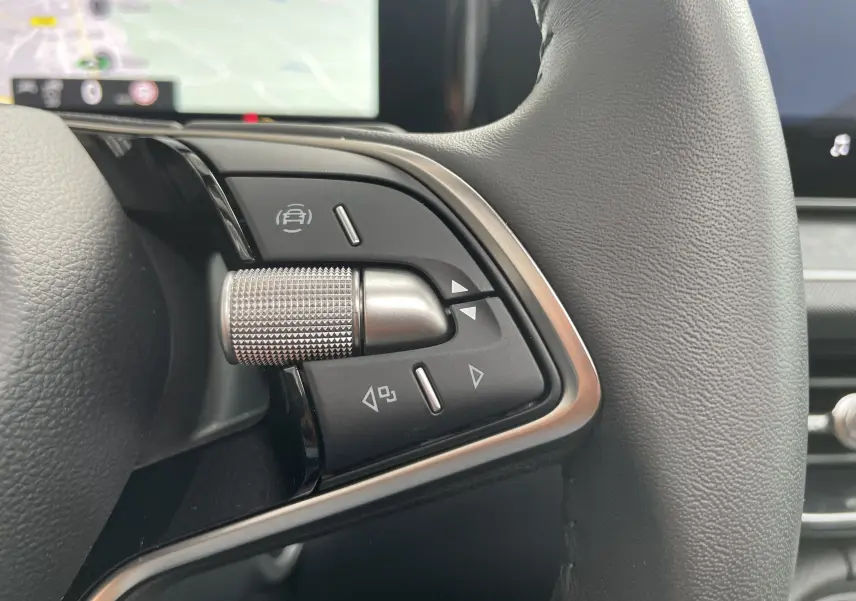 Gros plan sur les commandes multifonctions à gauche du volant cuir noir du Skoda Kodiaq 2024 finition Selection.