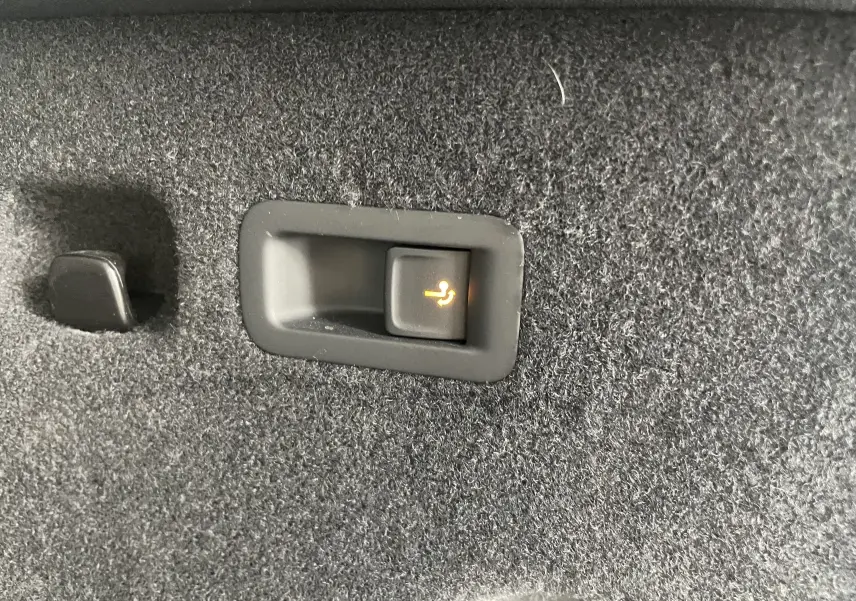 Bouton de rabattement électrique des sièges dans le coffre du Skoda Kodiaq noir métal 2024, version 7 places.