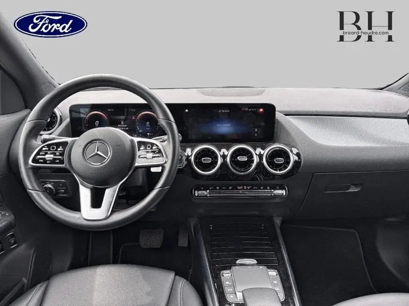 Intérieur noir du Mercedes GLA 250 e 2020 vu de face, avec volant multifonction et écran tactile large.