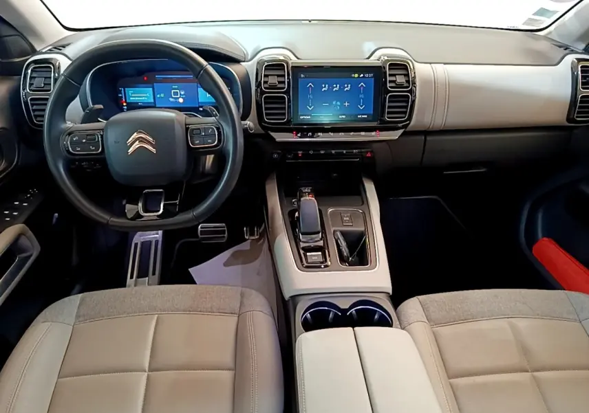 Vue intérieure avant du Citroën C5 Aircross Hybrid blanc, avec tableau de bord numérique et écran tactile central.