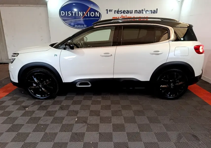 Vue latérale droite d'un Citroën C5 Aircross Hybrid blanc avec toit noir et jantes noires brillantes.