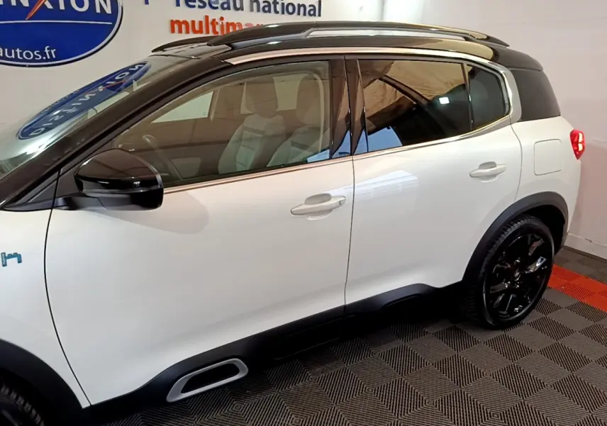 Vue de profil côté gauche d'un Citroën C5 Aircross Hybrid blanc avec toit noir et jantes noires.