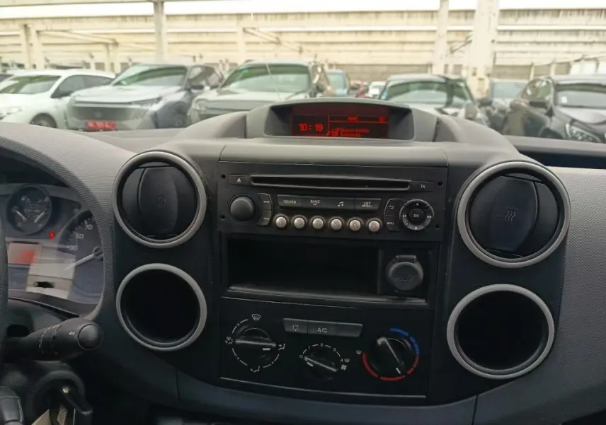 Tableau de bord intérieur du Citroën Berlingo XL blanc, vue frontale centrée sur la console radio et climatisation.