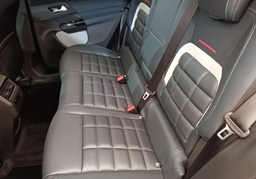 Vue intérieure côté droit des sièges arrière en cuir noir avec surpiqûres blanches du Citroën C5 hybride 2026.