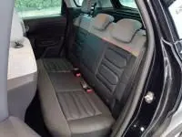 Vue intérieure arrière droite du Citroën C3 Aircross 2022 noir, montrant les sièges arrière en tissu et la porte ouverte.