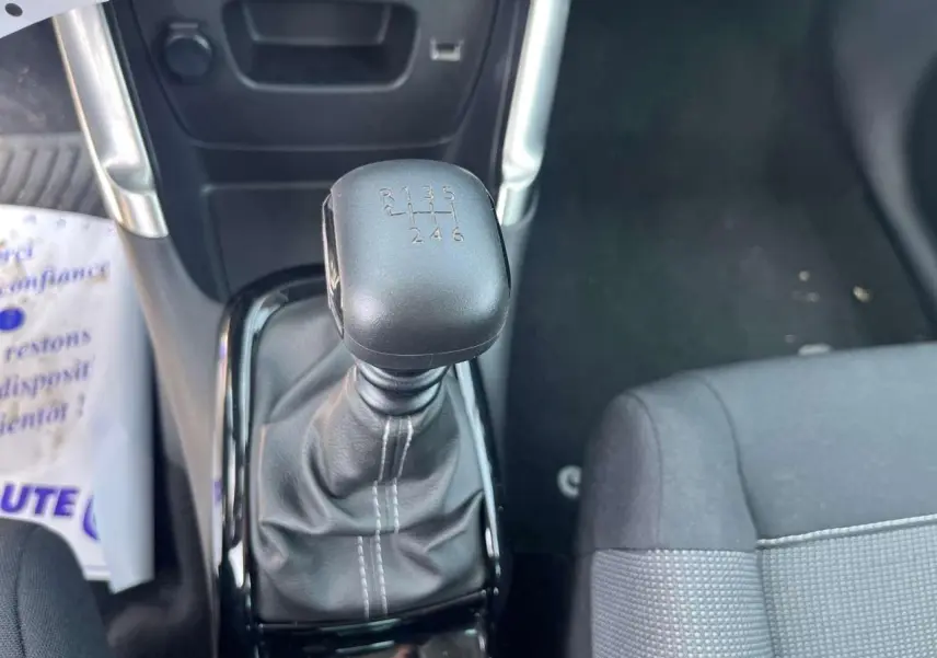 Le levier de vitesses manuel noir de la Citroën C3 Aircross 2023 vu de dessus avec siège tissu gris à droite.