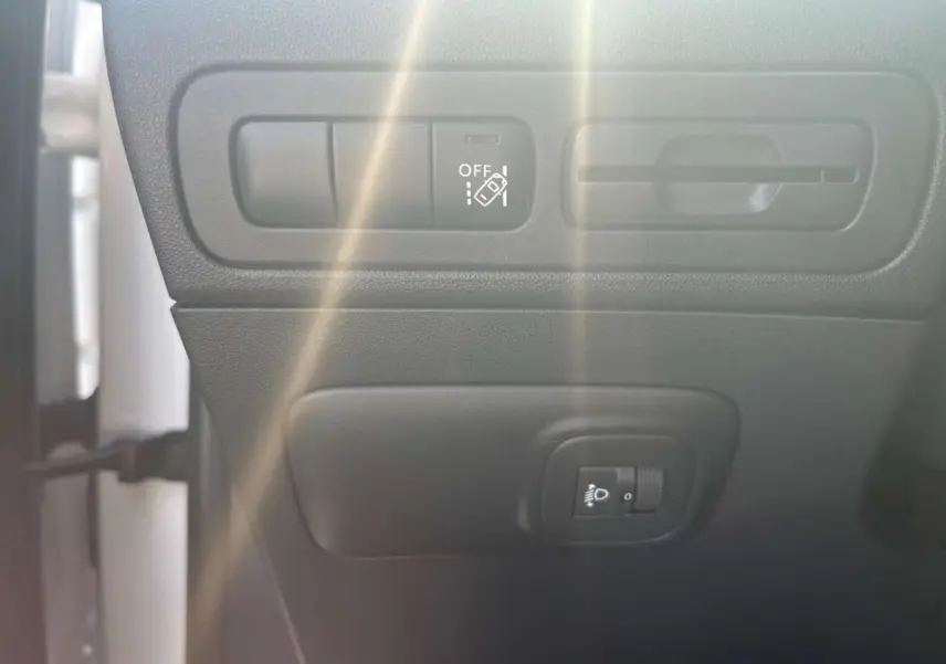 Détail des commandes d'aide à la conduite et réglage des phares dans l'habitacle du Citroën C3 Aircross blanc banquise.