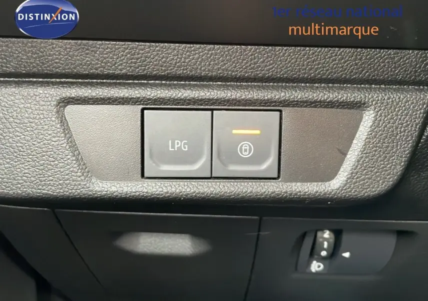 Gros plan sur les boutons de commande LPG et verrouillage intérieur du tableau de bord d'un Dacia Jogger gris schiste métal.