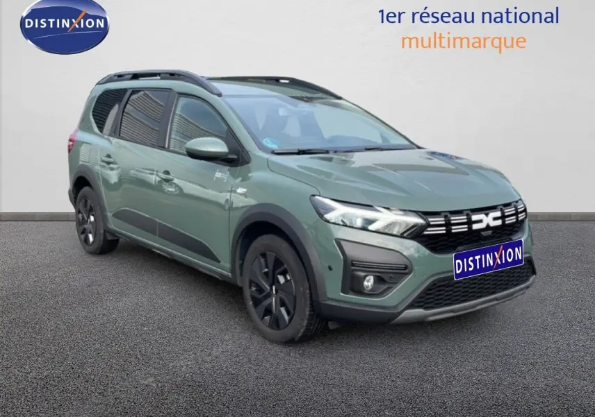 Dacia Jogger gris schiste métal en 3/4 avant droit, avec calandre noire et jantes noires distinctives.