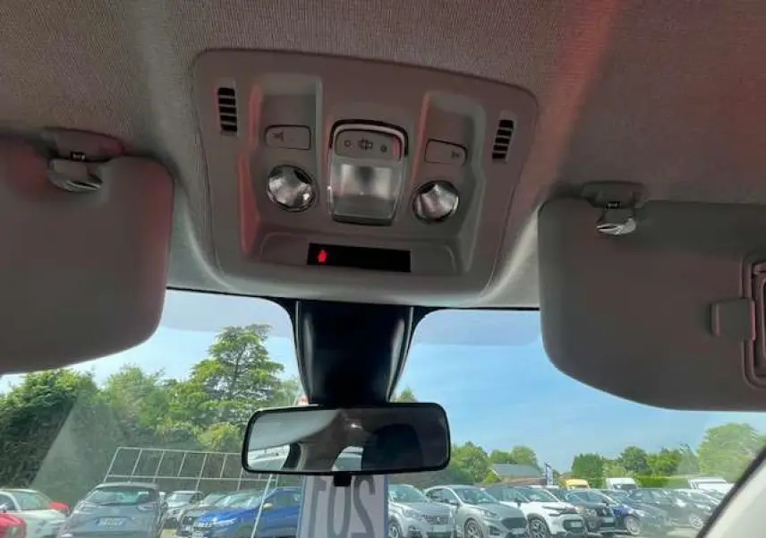 Vue intérieure du plafond et rétroviseur central d'une Citroën C3 noire métal 2023, avec pare-soleil baissé.