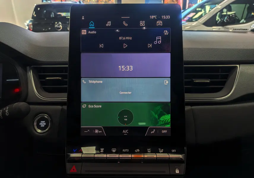 Écran tactile central allumé du tableau de bord du Renault Captur E-TECH 2025, intérieur noir moderne.