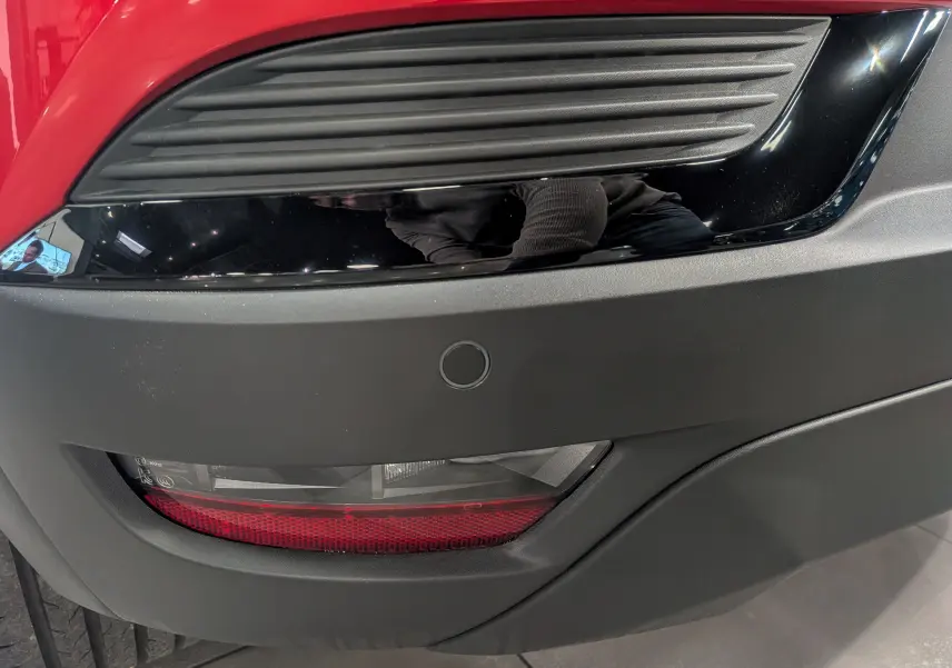 Gros plan sur le feu arrière et le pare-chocs noir mat du Renault Captur E-Tech rouge Flamme, version hybride 2025.