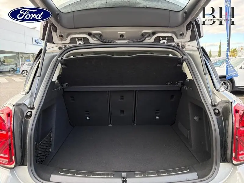 Coffre ouvert en vue arrière d'un MINI COUNTRYMAN Melting Silver III 2023, montrant l'espace de chargement et la banquette rabattable.