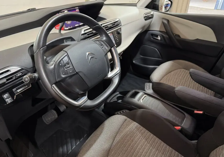 Vue intérieure côté conducteur de la Citroën C4 Spacetourer 2020, volant cuir noir et sièges bi-ton beige et noir.