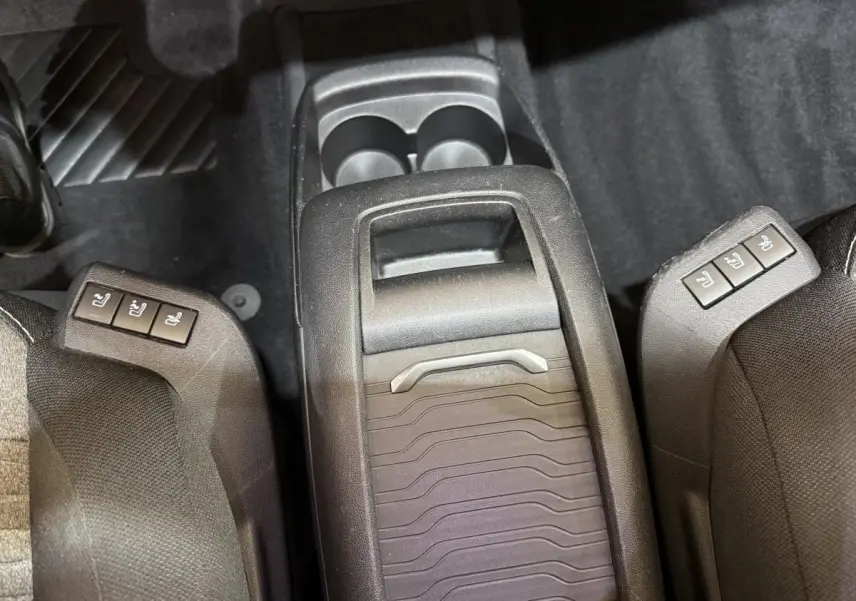 Vue plongeante sur la console centrale arrière noire du Citroën C4 Spacetourer avec commandes sièges chauffants.