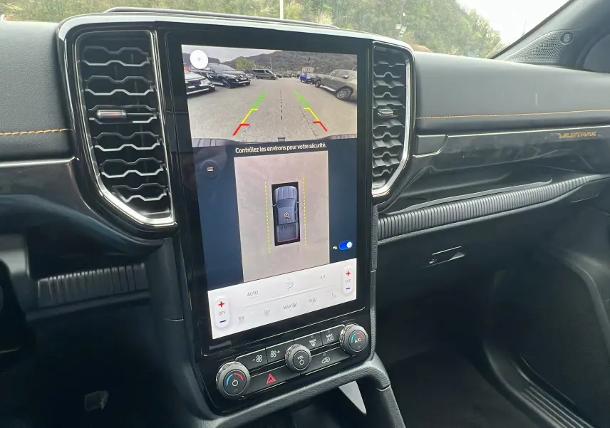 Vue intérieure centrée sur l'écran tactile du tableau de bord du Ford Ranger 2025 gris carbone Wildtrak Plus.