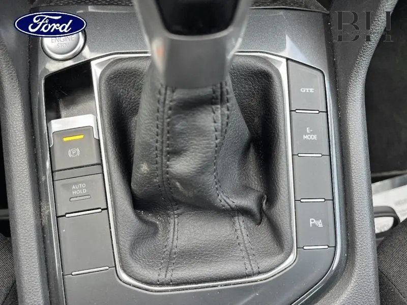 Gros plan sur la console centrale noire du Volkswagen Tiguan 1.4 eHybrid avec levier de vitesses et boutons GTE et E-MODE visibles.