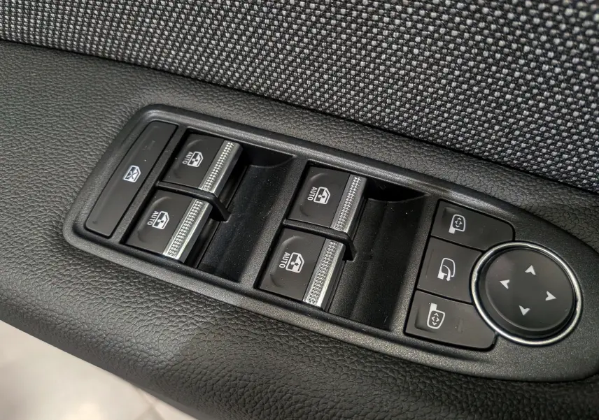 Gros plan sur les commandes des vitres électriques et réglages des rétroviseurs du Renault Captur E-TECH 2025.