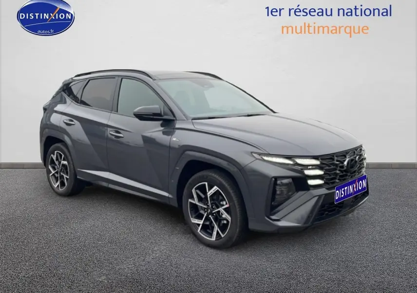 Vue 3/4 avant du Hyundai Tucson gris écotronique avec calandre N Line et jantes alliage 19 pouces design sportif.