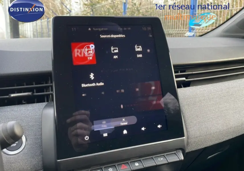 Écran tactile central de la Renault Clio 2025 rouge désir métal, affichant les sources audio disponibles.