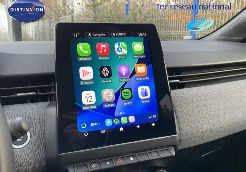 Vue rapprochée de l’écran tactile central de la Renault Clio rouge Désir Métal, affichant l’interface multimédia.