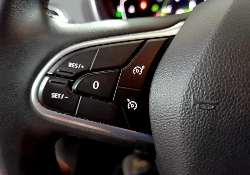 Gros plan sur les commandes du régulateur de vitesse du volant noir de la Renault Mégane Business Blue dCi 115 EDC 2021.
