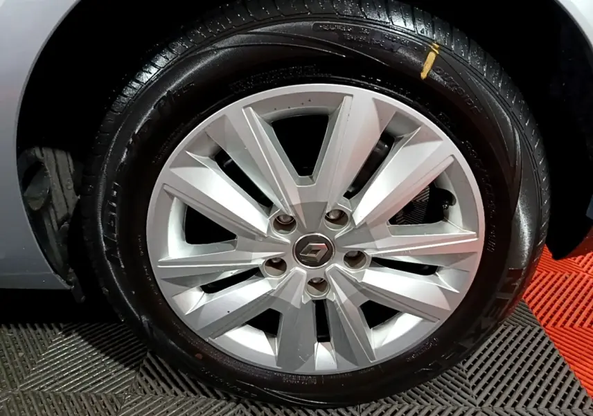 Gros plan sur la roue avant droite de la Renault Mégane Business Blue dCi 115 EDC gris clair avec jante alliage argentée.