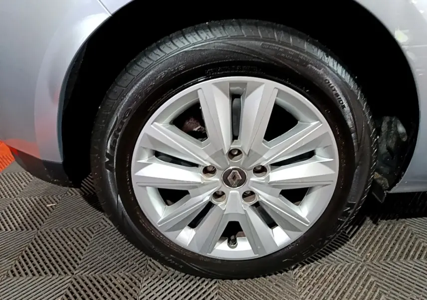 Gros plan sur la roue avant gauche grise d'une Renault Mégane Business Blue dCi 115 EDC avec jante alliage argentée.