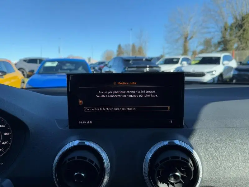 Vue intérieure du tableau de bord de l'Audi Q2 30 TDI S line 2024, écran central affichant la connexion Bluetooth.