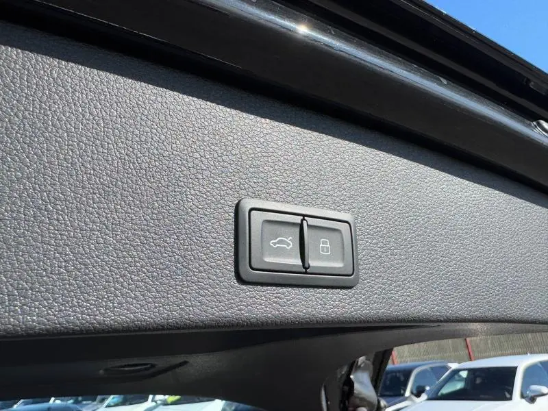 Gros plan sur les boutons d'ouverture et de verrouillage du coffre du coffre d'un Audi Q2 noir Mythic métallisé 2024.