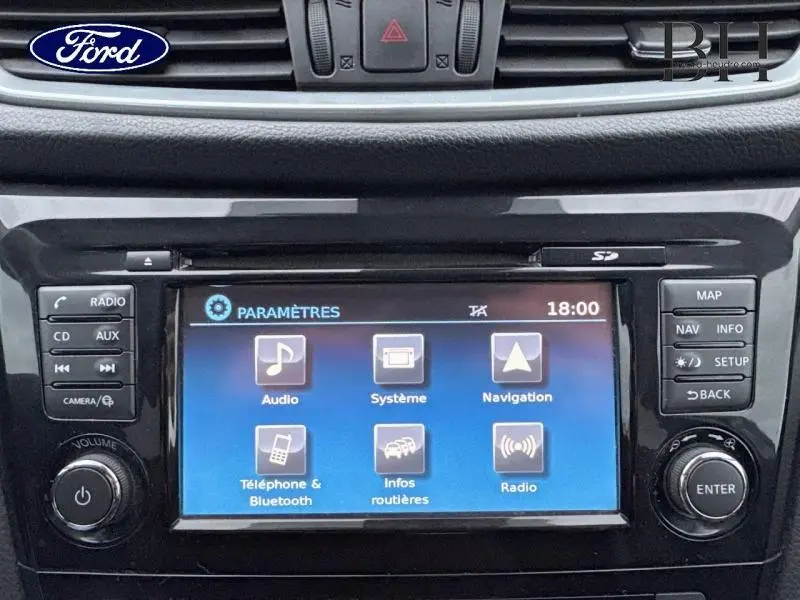 Écran tactile central du Nissan Qashqai 2018 en gros plan, affichant le menu paramètres sur fond bleu.