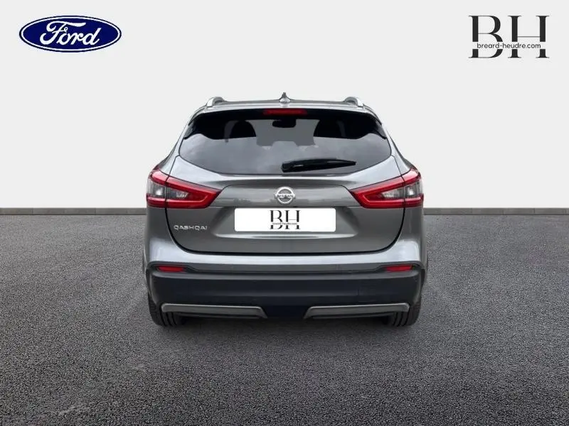 Vue arrière du Nissan Qashqai gris Squale 2018 avec feux LED et barres de toit visibles sur fond neutre.