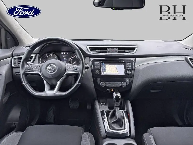 Intérieur avant d'un Nissan Qashqai gris Squale 2018, volant cuir multifonction et écran tactile GPS central.