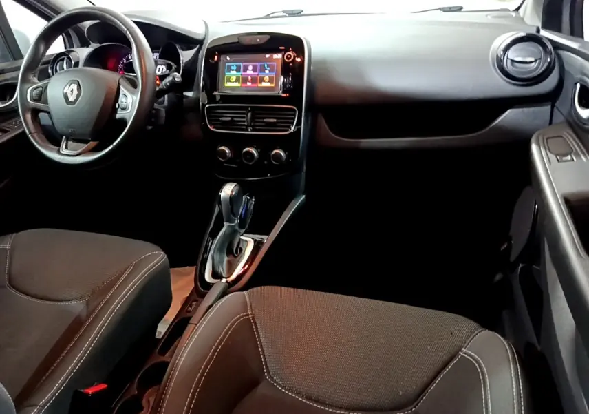 Vue intérieure avant droite de la Renault Clio Business 2018, volant cuir multifonctions et écran tactile central allumé.