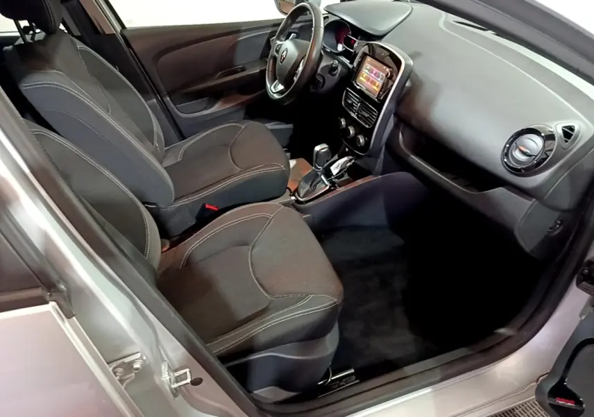 Vue intérieure côté conducteur d'une Renault Clio Business gris clair 2018 avec volant cuir multifonctions et écran tactile central.