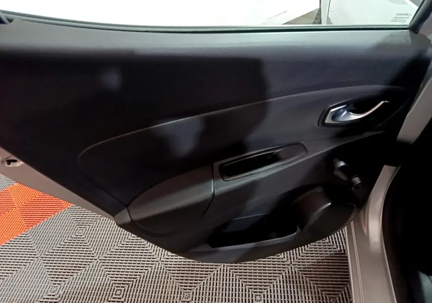 Vue intérieure de la porte côté droit de la Renault Clio Business gris clair, avec poignée et haut-parleur intégrés.