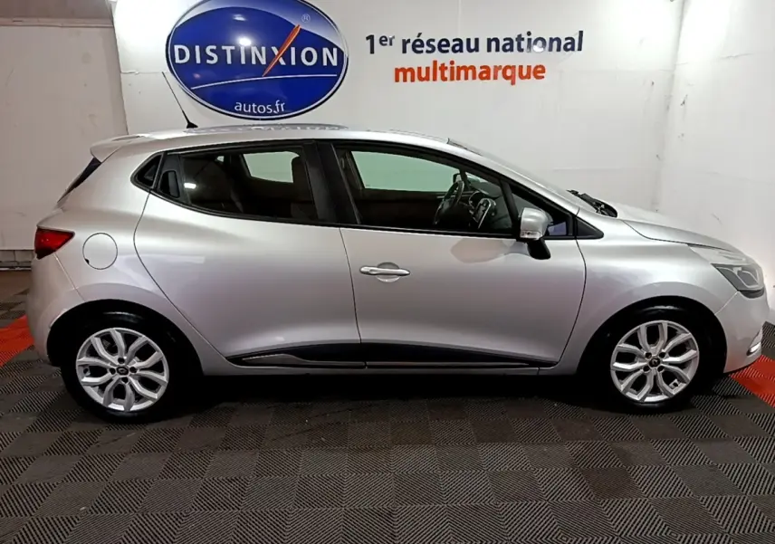 Profil droit d’une Renault Clio Business dCi 90 EDC gris clair 2018 en intérieur, avec jantes alliage et vitres teintées.