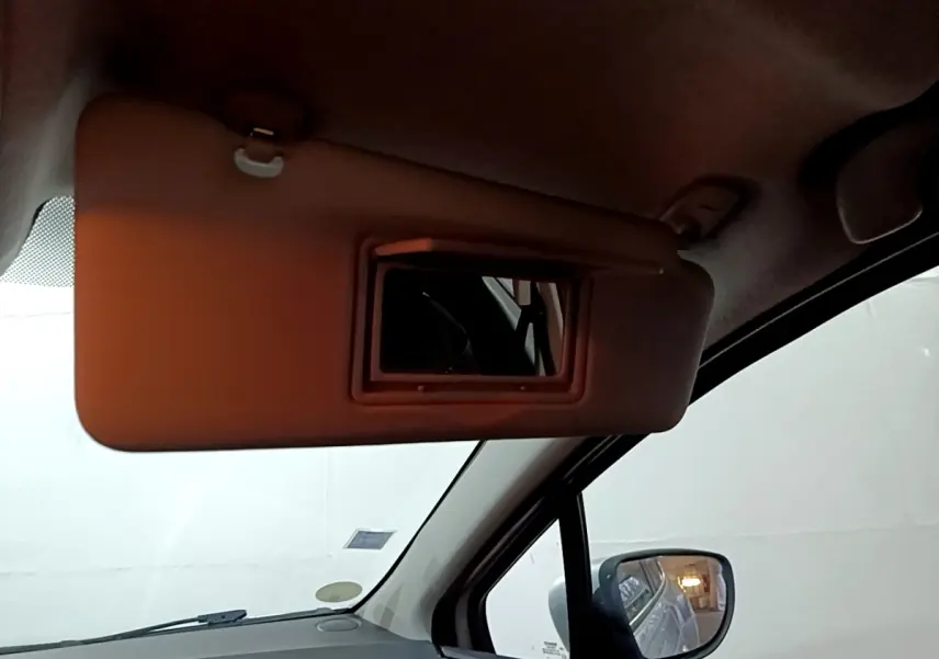 Détail du pare-soleil avec miroir intégré côté conducteur dans une Renault Clio gris clair de 2018.