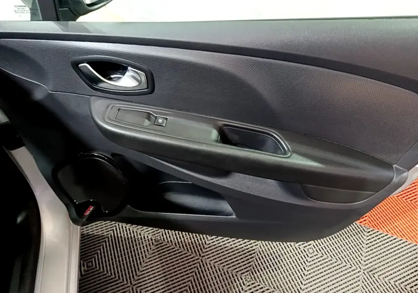 Vue rapprochée de la porte avant gauche gris clair d’une Renault Clio Business 2018 avec poignée et commande de vitre.