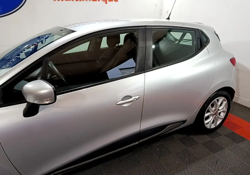 Profil côté gauche d'une Renault Clio Business gris clair de 2018, avec jantes alliage et rétroviseur assorti.
