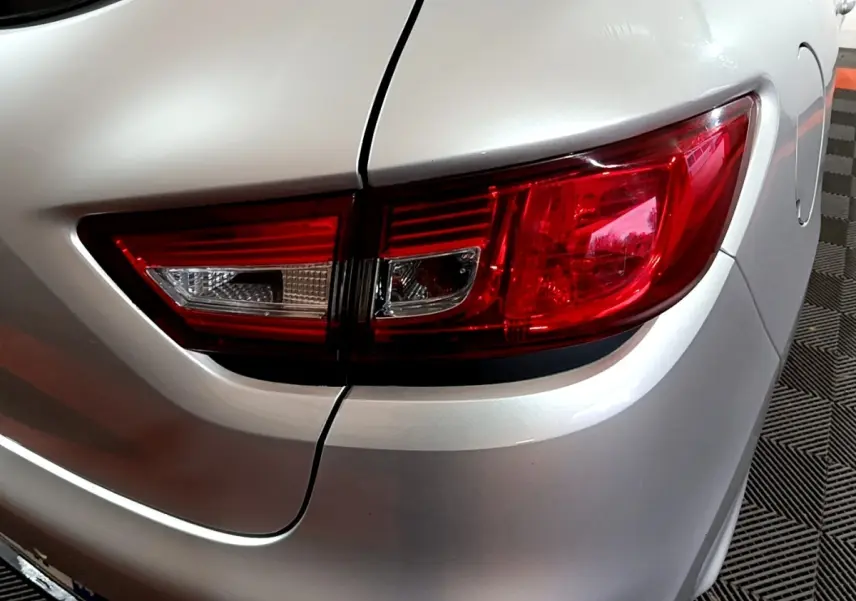 Gros plan sur le feu arrière droit d'une Renault Clio Business gris clair de 2018, détails nets et contours précis.