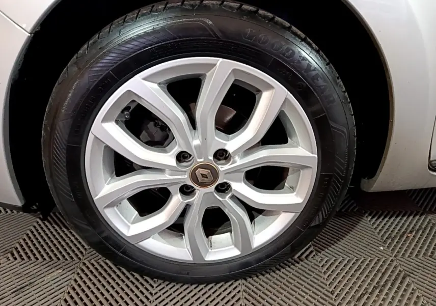 Gros plan sur la roue avant droite d’une Renault Clio Business gris clair avec jante alliage à motif moderne.