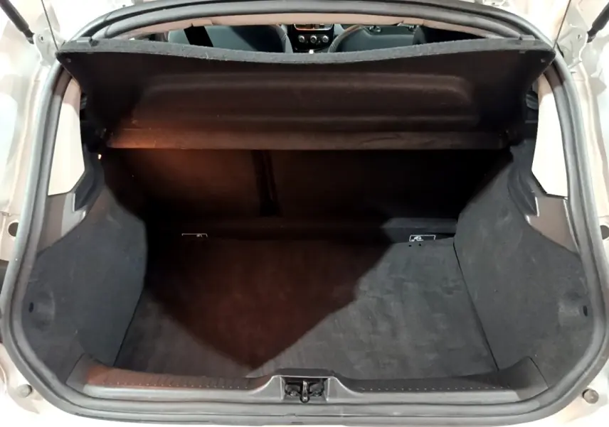 Coffre ouvert vu de l'arrière d'une Renault Clio Business gris clair, montrant l'espace de chargement vide et la tablette arrière.