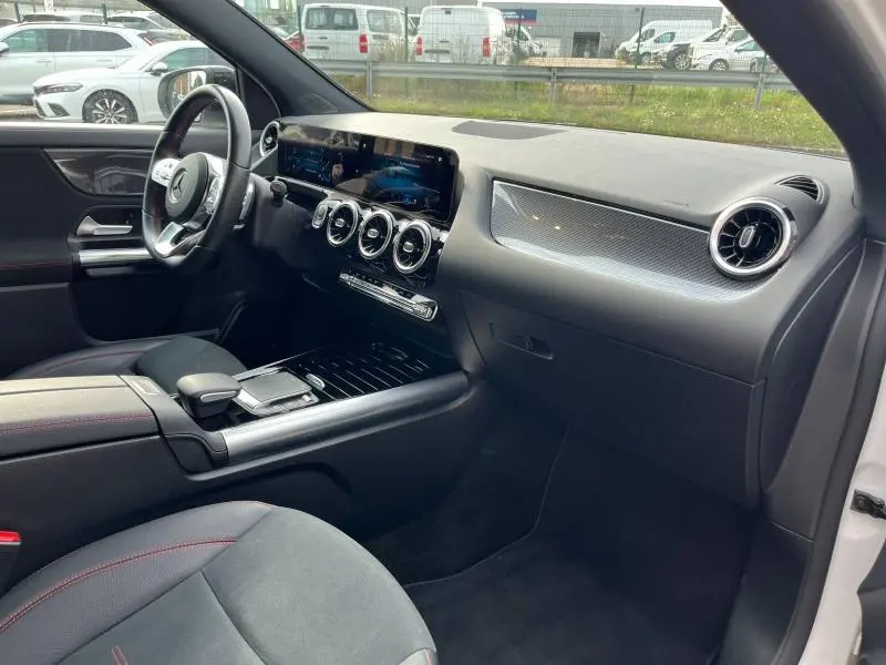 Intérieur noir du Mercedes GLA 200 AMG Line 2022 vu côté passager, avec tableau de bord moderne et écran tactile large.