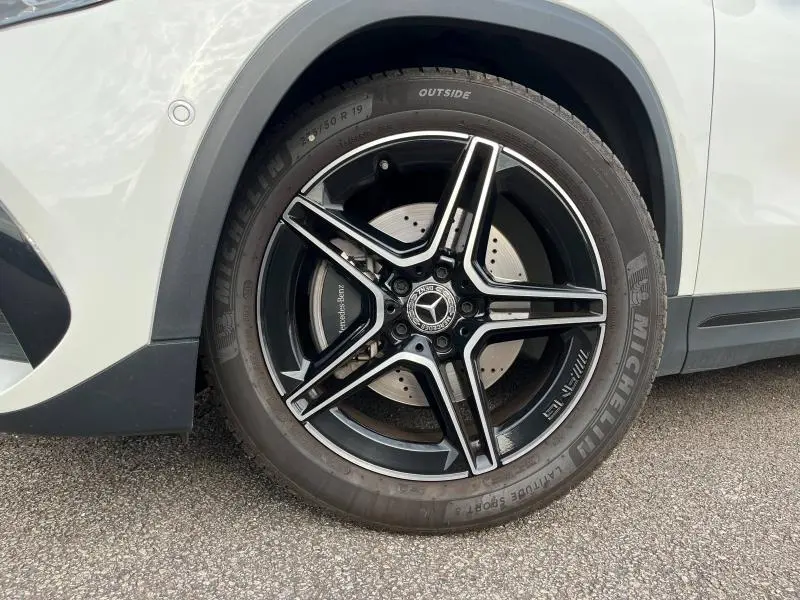 Gros plan sur la jante AMG noire et argent de 19 pouces du côté avant droit d'un Mercedes GLA blanc polaire 2022.