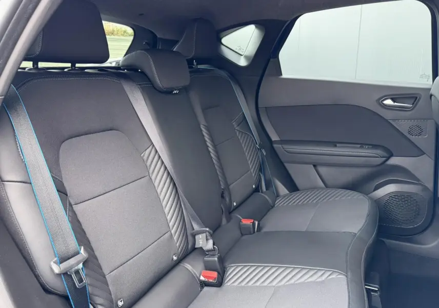 Vue intérieure côté droit des sièges arrière noirs avec surpiqûres bleues du Renault Captur Esprit Alpine 2025.