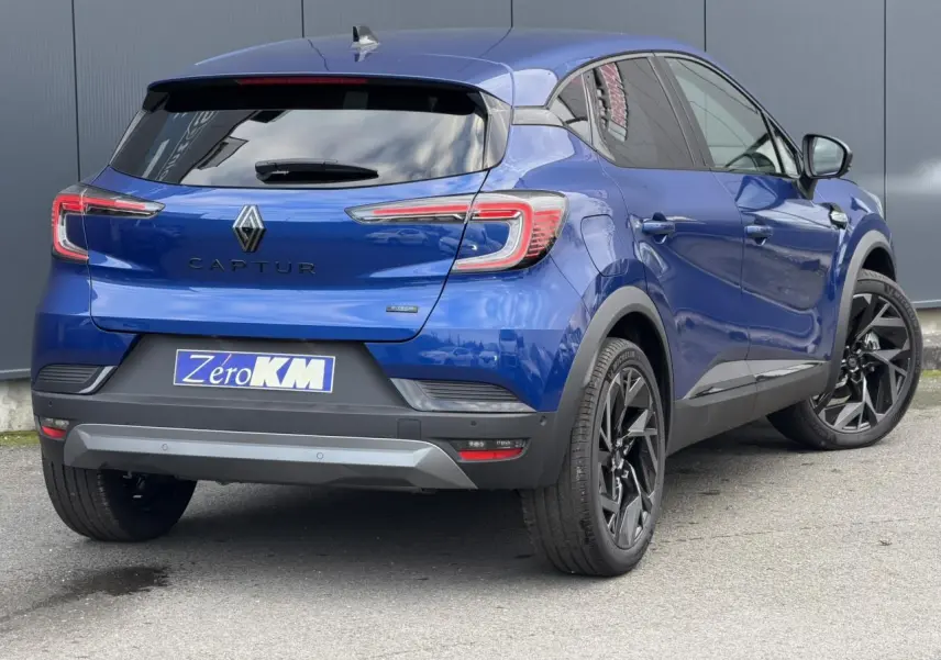 Vue 3/4 arrière droite du Renault Captur 2025 Bleu Iron avec jantes noires et vitres surteintées.
